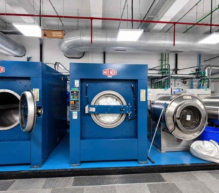 Three ADC industrial tumble dryers in drying section of Taj Palace Mumbai laundry facility installed by Supershine