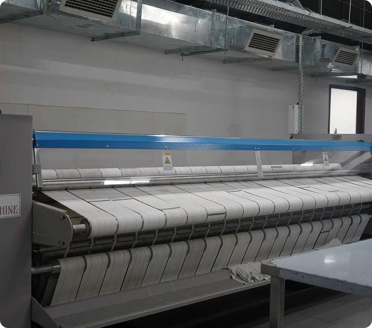 Large flatwork ironer processing linen at Lady Hardinge Medical College and Hospital's industrial laundry facility, New Delhi