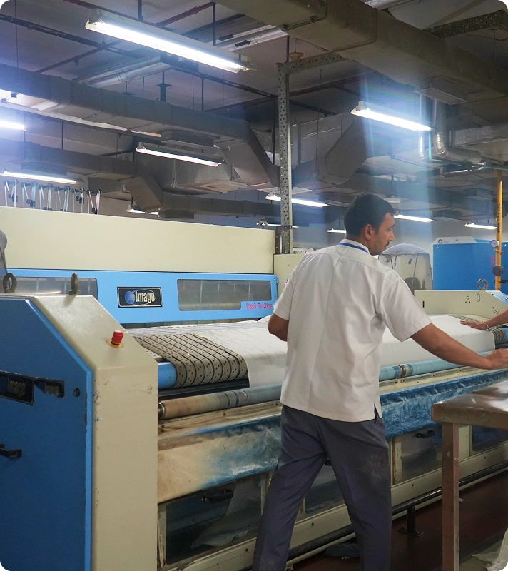 Technician operating an Image Laundry Systems flatwork ironer at Medanta Hospital's in-house laundry facility, Gurugram