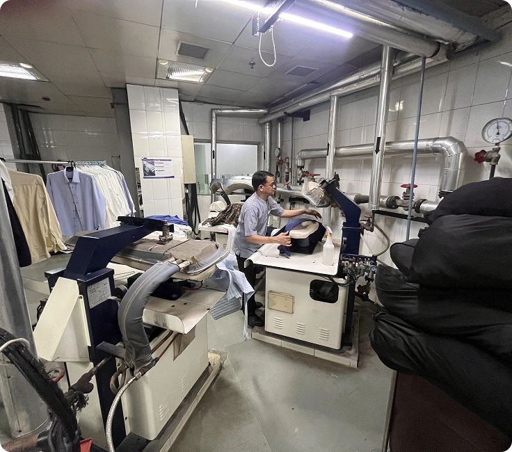 Laundry staff operating washer extractors and flatwork ironer at Holiday Inn Aerocity's in-house laundry facility, New Delhi