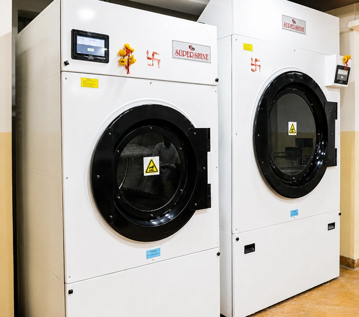 Complete Supershine laundry room installation with dryers stacked washers and washer extractor at Damodar Dham Nathdwara