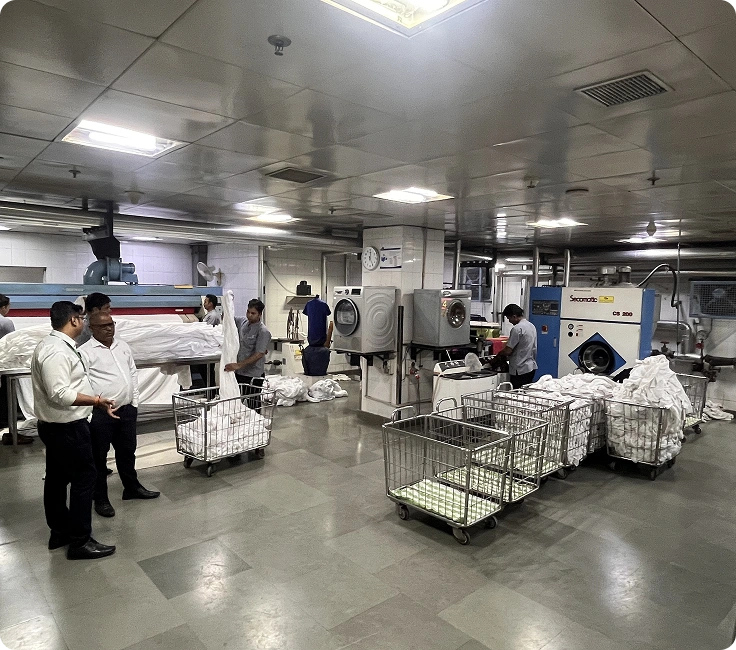 Full view of in-house laundry operations with washer extractors and linen trolleys at Holiday Inn Aerocity, New Delhi