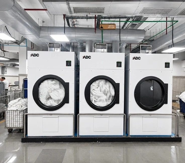 Three ADC industrial tumble dryers in drying section of Taj Palace Mumbai laundry facility installed by Supershine